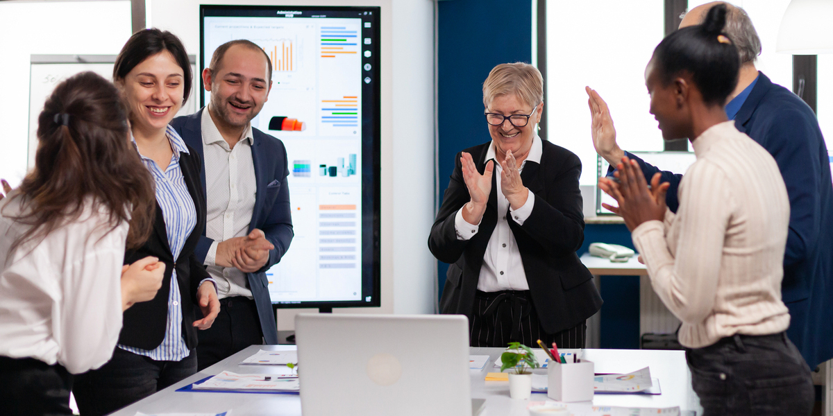 iFama image showing business people applauding business plan success on computer